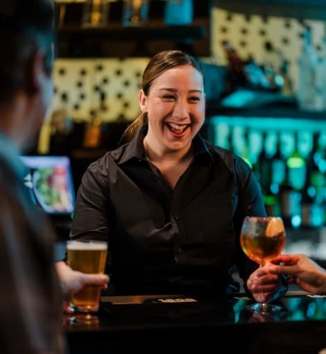 woman smiling serving drinks